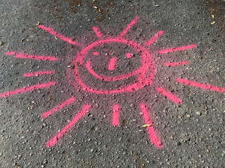 red sun kids drawing on asphalt