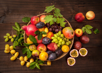 Fresh ripe summer fruits on plate on wooden background.