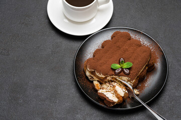 portion of Classic tiramisu dessert and cup of fresh espresso coffee on concrete background