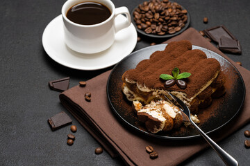 portion of Classic tiramisu dessert and cup of fresh espresso coffee on concrete background
