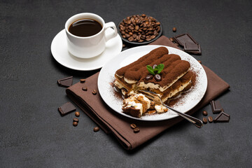 portion of Classic tiramisu dessert and cup of fresh espresso coffee on concrete background