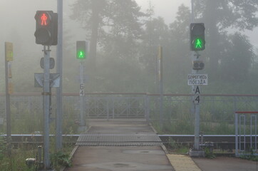Dedenevo. Moscow region. Russia. June 26. 2020 Pedestrian crossing over railway tracks on a foggy...