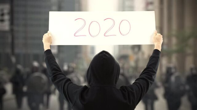 Unknown protester holds a placard with 2020 text