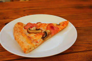 slice of pizza on a white plate on the table