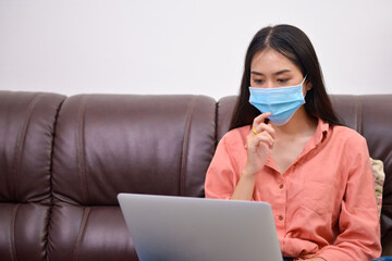 woman learning online at home with mask.