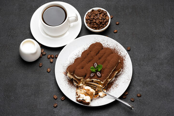 portion of Classic tiramisu dessert and cup of fresh espresso coffee on concrete background