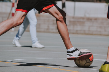 Las piernas de un chico delgado corriendo detrás del balón de fútbol - obrazy, fototapety, plakaty