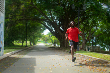 Happy man with headphones running outdoors