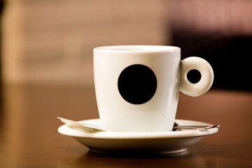 Fresh hot coffee on wooden table in cafe interior and free space for your decoration.