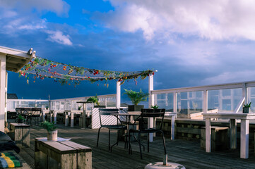  Empty terras of a beach club decorated with a net with artificial flowers