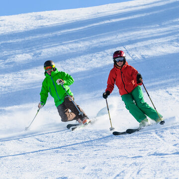 Skifahrerin und Telemarker gemeinsam auf der Piste unterwegs
