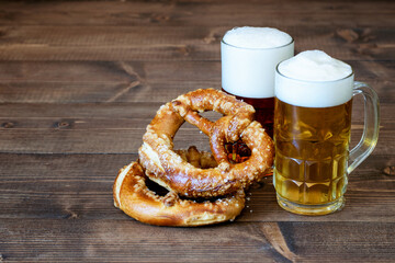 Dark and light beer, pretzels on the wood background, perfect for October fest. Front view, copy space.