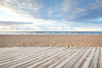 An empty modern wooden promenade through the sandy shore of the Baltic sea. Sport, recreation,...