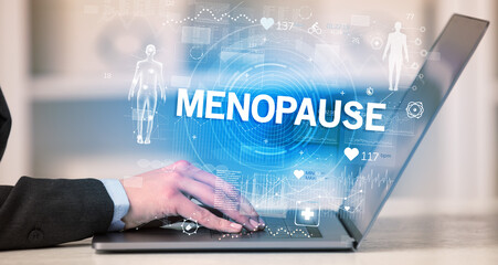 Doctor working a health check with MENOPAUSE inscription, recording medical test results