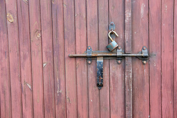 Vintage wooden garage door wth padlock and old metal hasp