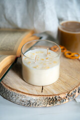 The candle is handmade from soy wax with the scent of peaches on a wooden stand. High quality photo