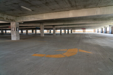 View of Level 6 of Empty Large Parking Lot With YEllow Arrow in the floor