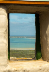 view from old window onto turquoise lake sea lagoon