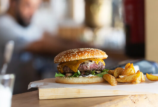 Freshly prepared burger on wooden board with copy space