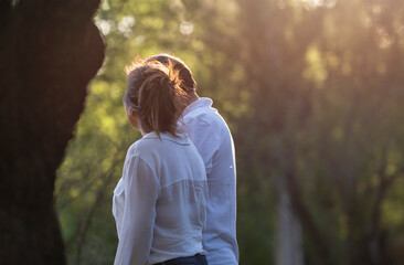 couple walks in a park in a sunset