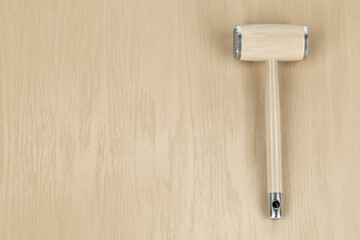 Meat tenderizer on wooden table, top view