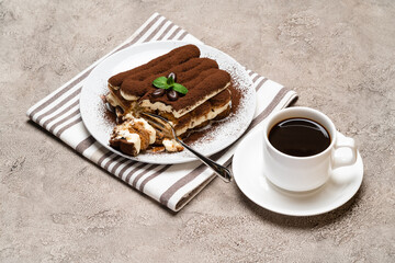 portion of Classic tiramisu dessert and cup of fresh espresso coffee on concrete background