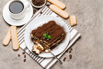 portion of Classic tiramisu dessert and savoiardi cookies on concrete background