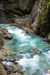 Naklejka na ściany i meble Clean, beautiful, mountain river flows through a rocky gorge Partnachklamm in Germany incised by a mountain stream near the Garmisch-Partenkirchen.