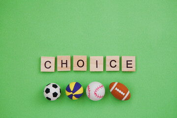 Collection of sport balls and inscription on wooden blocks Choice isolated on green background. Copy space.