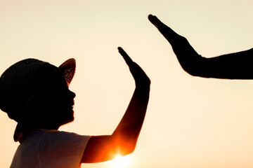 A Hands of happy father and child by the sea on nature silhouette travel