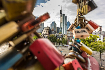 Frankfurt / Main, Germany - September 03rd 2020: A german photographer visiting the "Eiserner Steg" with its love locks. View along the river Main to the skyline of the financial district Frankfurt.