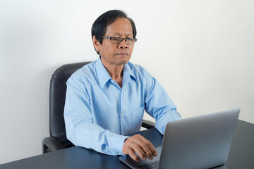 Portrait of Asian senior man using laptop