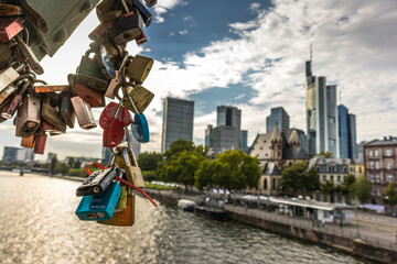 Frankfurt / Main, Germany - September 03rd 2020: A german photographer visiting the "Eiserner Steg" with its love locks. View along the river Main to the skyline of the financial district Frankfurt.