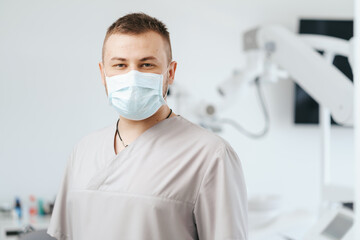 Fototapeta na wymiar Portrait of man dentist wearing medical mask in dental clinic