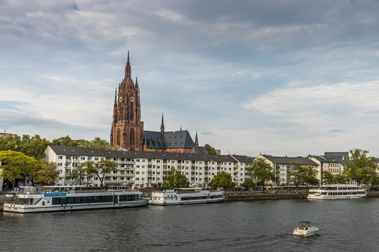 Frankfurt / Main, Germany - September 03rd 2020: A german photographer visiting the "Eiserner Steg" at a sunny day. View along the river Main to the so called Frankfurter Dom.