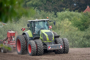 Obraz premium tractor brings new seeds into the soil