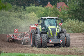 Obraz premium tractor brings new seeds into the soil