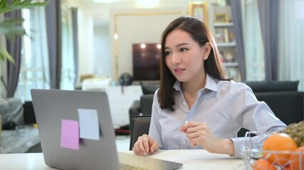 A beautiful young business woman  is making video conference call via computer at home , business technology concept . - Powered by Adobe