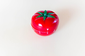 Red tomato-shaped timer on white background. Home related, home staying. Free copy space.
