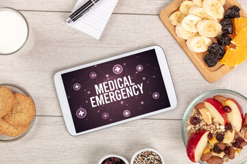 MEDICAL EMERGENCY concept in tablet pc with healthy food around, top view