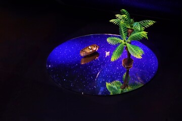 Miniature people sitting on boat travel on the ocean at night