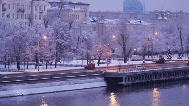 Moscow, Russia - January 11, 2020: Evening city in the snow after a heavy snowfall. Cars go along the embankment of the Moskva River at dusk. Beautiful landscape views in winter of historic center