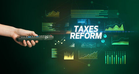 hand holding wireless peripheral with TAXES REFORM inscription, cyber business concept