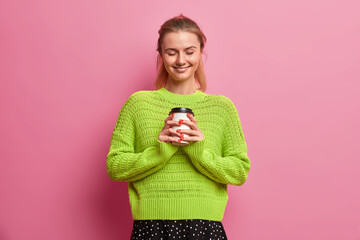 My morning starts from coffee. Happy positive European woman holds disposable cup of tasty drink,...