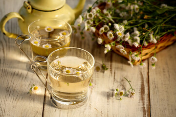 Fresh chamomile tea on a wooden table