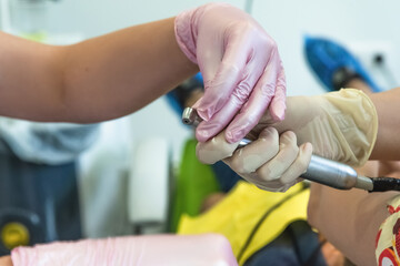 Close-up of doctors hands with a dental drill in a dental clinic. Health care and treatment concept