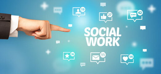 Close-Up of cropped hand pointing at SOCIAL WORK inscription, social networking concept