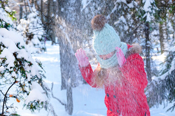 Blurred photo. Girl snowfall on the background of the forest. A child under the snow. Bad weather...