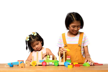 Asian two sisters kids playing together on a wooden table with white background. Skill of children, Childhood roles and Birth order, Child development concept