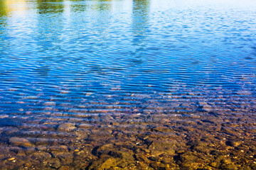 blue water reflection with stones in the morning 
